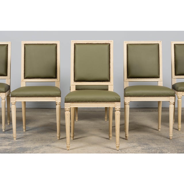 An exquisite set of eight French Louis XVI style restored dining chairs, consisting of six side chairs and two armchairs,...