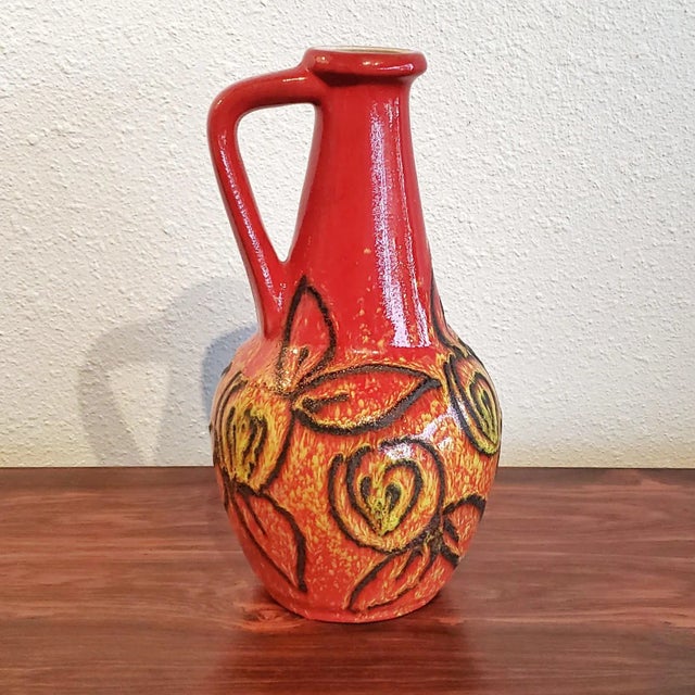 A fiery red, yellow, and black handle vase Nr. 61/30 from Bay Keramik with a raised volcanic floral or fruit decor, and an...