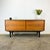 Straight-lined sideboard made in Germany with a wonderful contrast of light walnut and black. The two sliding doors are...