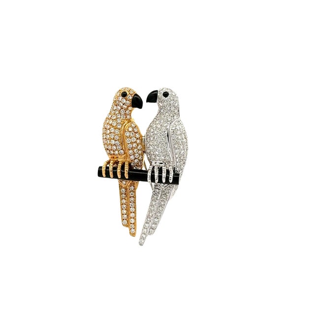 A captivating brooch depicting love birds perched together. The lovers are encrusted with 2.70 carats of round white...
