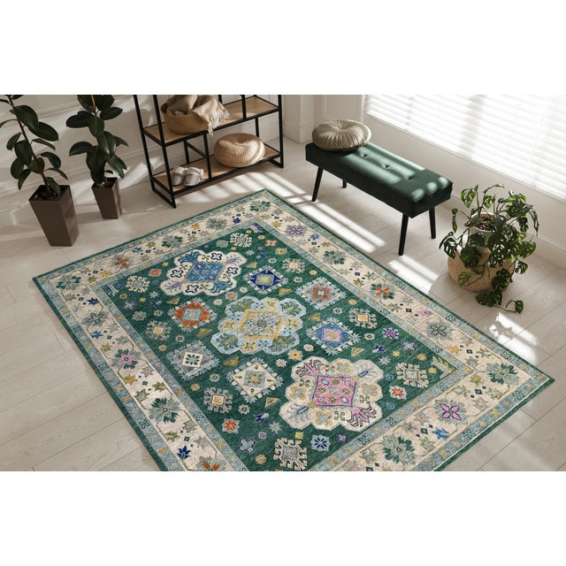 Isla Kazak Green Hand Knotted Wool Rug, Country of Origin: India. This exquisite piece captures the robust geometric...