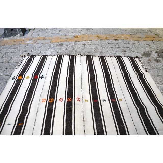 This is a vintage Turkish Anatolian kilim rug from the 1960s. The piece was hand-woven.