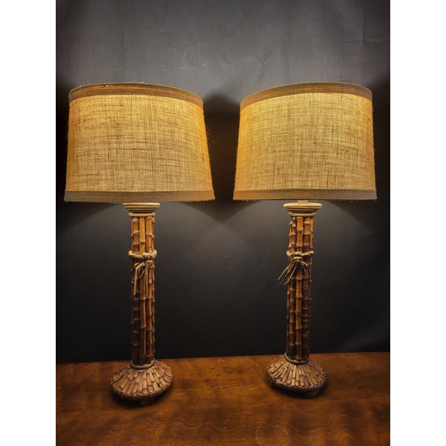 A striking pair of vintage table lamps handcrafted from clustered natural bamboo, featuring beautifully detailed split-...