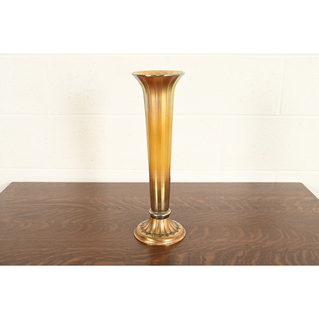 A gorgeous Arts & Crafts or Art Nouveau period Favrile iridescent art glass tall trumpet vase on gilt bronze enameled...
