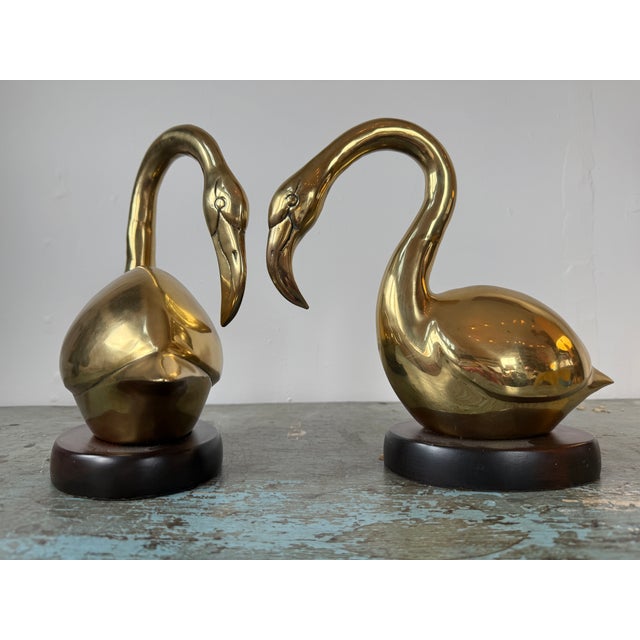 Striking Pair of Vintage Brass Flamingos, curving their necks almost in a heart shape toward each other. This elegant set...
