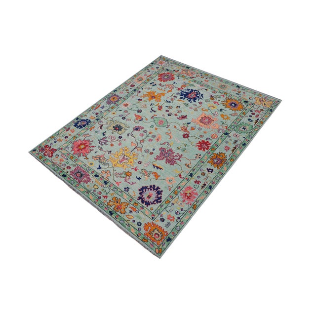 Enhance the ambiance of your home with this magnificent Persian-influenced Turkish hand-knotted rug made by skilled...