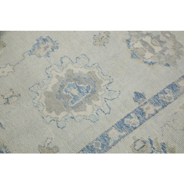 This modern Turkish Oushak rug is a stunning piece of art that has been handwoven using traditional techniques by skilled...