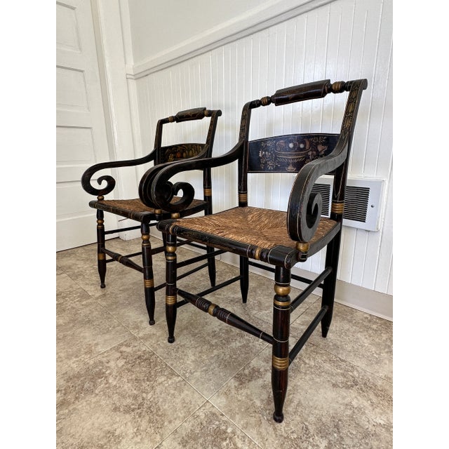 A pair of antique (reproduced) Hitchcock arm chairs with wicker seating. Beautifully painted and carved detailing. You can...