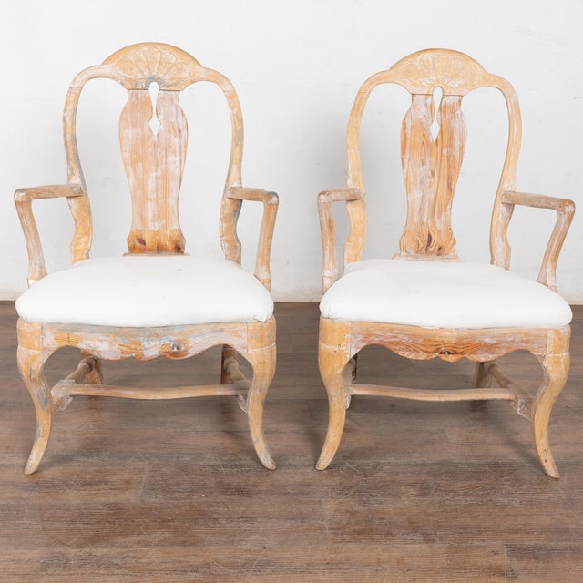 This graceful pair of Swedish Gustavian arm chairs have a wonderfully warm patina thanks to the soft, scraped finish...