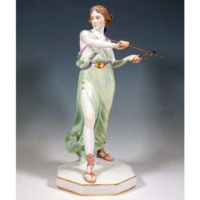 A highly decorative, full-sculptural representation of an art nouveau beauty with hair artfully tied back with a large...