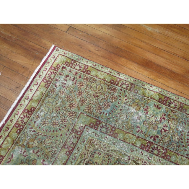 An early 20th-century worn Persian Lavar Kerman traditional room size rug. Measures: 8'4'' x 12' The province and city of...