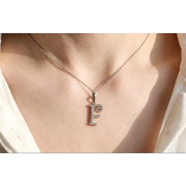 This modern 18K white gold pendant necklace features a "F" initial slide accented with brilliant diamonds totaling 0.4...