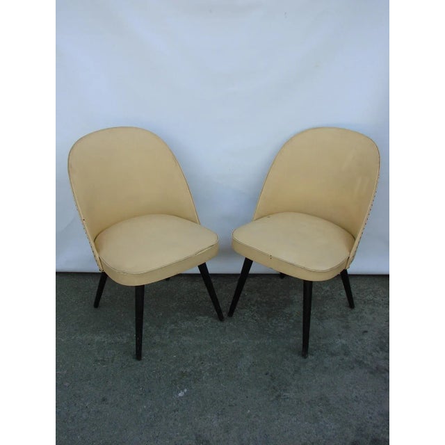 This pair of chairs from the 1960s is made from wood and vinyl and remain in an original condition.
