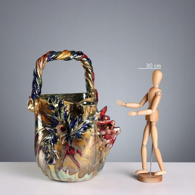 Ceramic pourer with a metallic luster. Artistic animal and plant decoration and a twisted handle. Signature painted under...