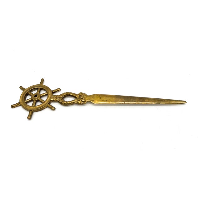 Charming vintage brass letter opener featuring a nautical ship’s wheel motif with a twisted rope detail at the neck. Solid...