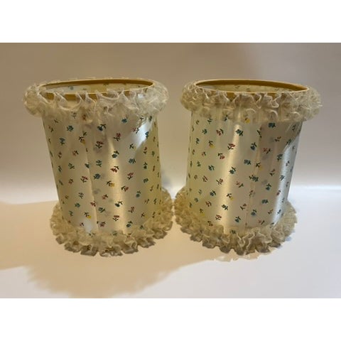 A matching pair of vintage drum shaped bulb clip table lamp shades featuring a small scale floral pattern and ruffled lace...