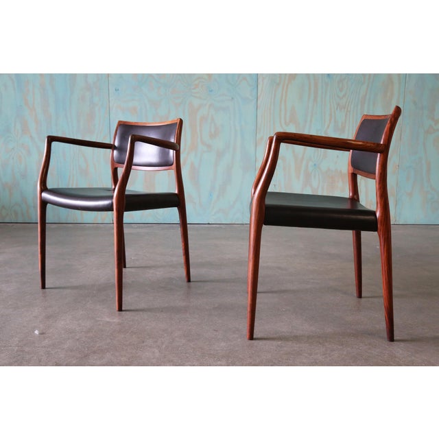 A pair of sculptural lounge chairs in carved solid exotic rosewood and original leather. these chairs are iconic mid...
