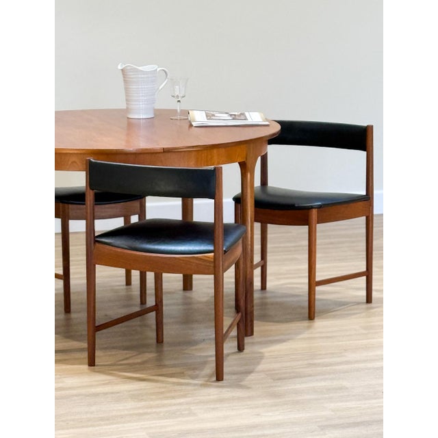 A refined expression of mid-century craftsmanship, this round extending dining table with four chairs was designed by Tom...