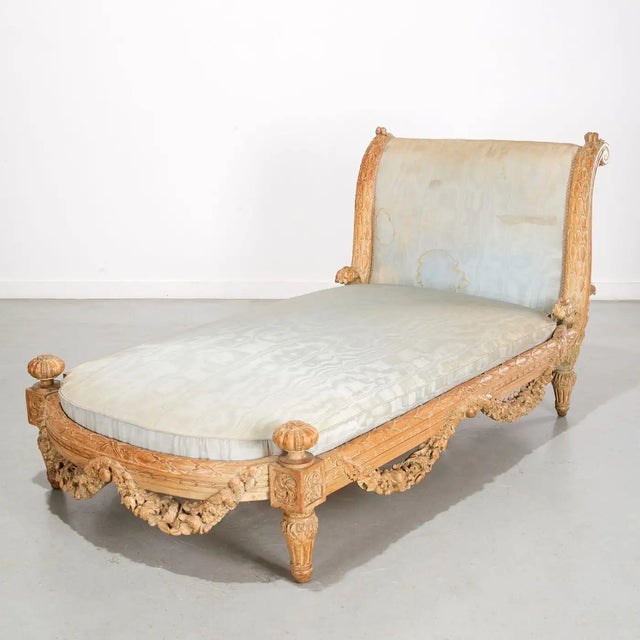 19th Century French Louis Philippe Neoclassical Daybed. Richly carved laurel leaf frame draped with floral swags, scrolled...