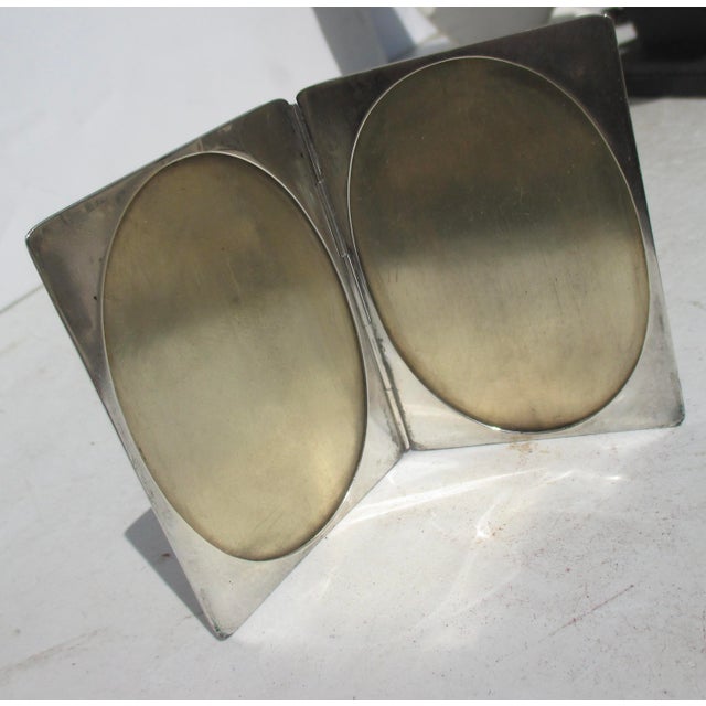 Sterling silver traveling frame. Wallet thin with two oval frame windows inside. marked sterling to the inside edge. A...