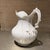 For your consideration, antique white porcelain pitcher features delicate gold trim accents and a ornate scalloped handle....