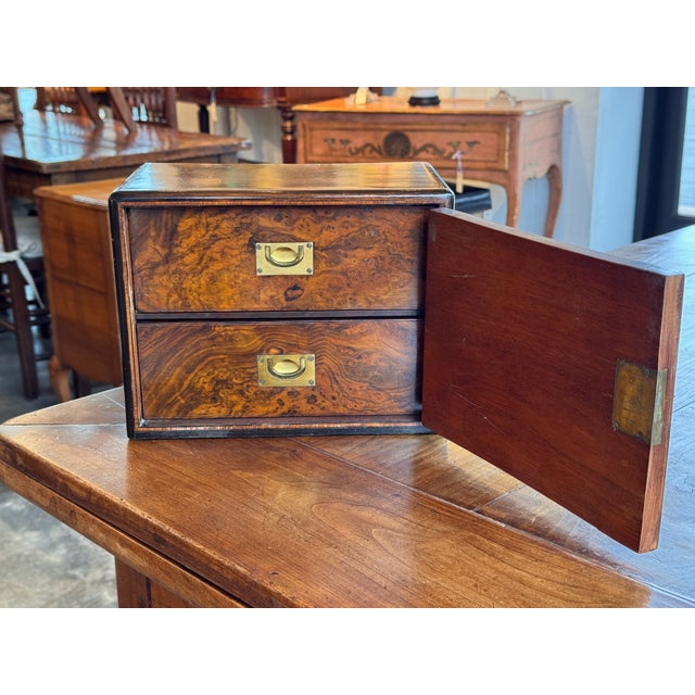 Rectangular box fitted with a hinged side door opening to two interior drawers, each with recessed brass pulls. The...