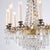 French antique crystal chandelier from around 1890, designed with prisms and decorative details in gilt bronze. The...