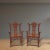 This pair of 20 century antique armchairs is adorn with elaborate carving on the back splat and around the chairs and...