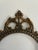 A striking vintage solid brass oval frame with a scrolled crown and finial, openwork sides, and a beaded edge around the...