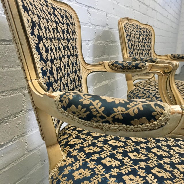 Chic pair of antique French Fauteuil armchairs. Upholstered in a rich damask fabric with a classic climbing vine print....