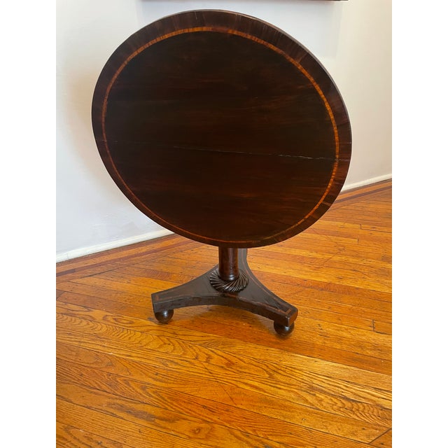 Gorgeous diminutive carved rosewood with inlaid tilt-top occasional table. This lovely work retains its original finish in...