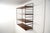 Wall system of Italian production from the 60s. Lacquered metal supports, four shelves with teak wood finish of great...