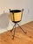 Classic 1950's Mid-Century Modern plant stand design, featuring popular atomic-era and industrial elements. The stand is a...