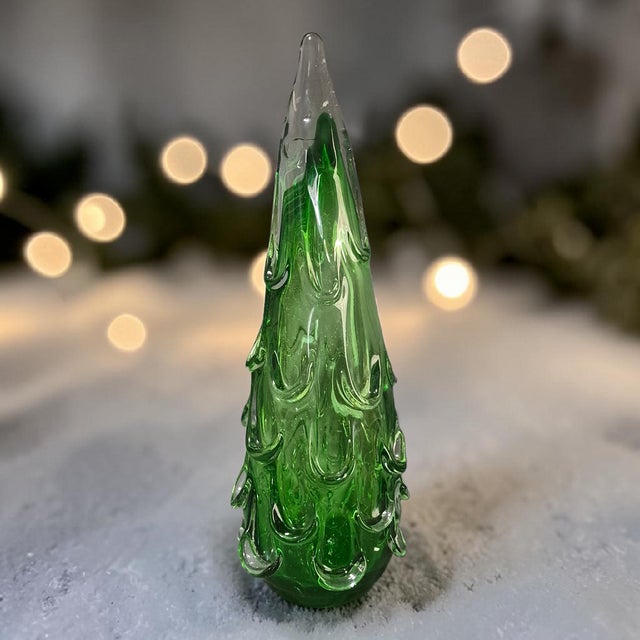 This product is a hand-blown art glass Christmas tree from Italy, measuring 16.5 inches in height. The tree is made of...