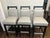 Set of five transitional or contemporary swivel bar stools featuring light gray leather upholstery paired with sleek black...