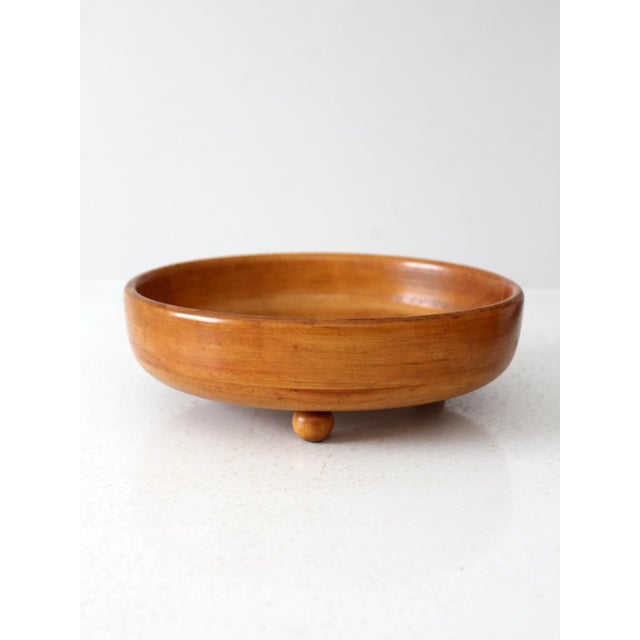 This vintage mid-century footed wooden bowl features a warm wood tone and timeless shape that works beautifully as a...
