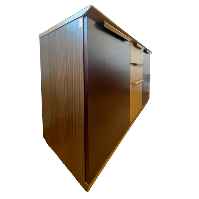 A leather wrapped case, in a dark brown leather with light brown contrast drawers, with two doors, enclosing interior...