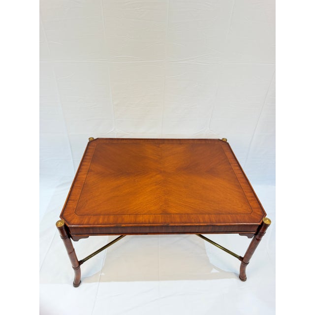 A richly detailed vintage coffee table in the style of Maitland-Smith, combining a beautifully figured wood top with...
