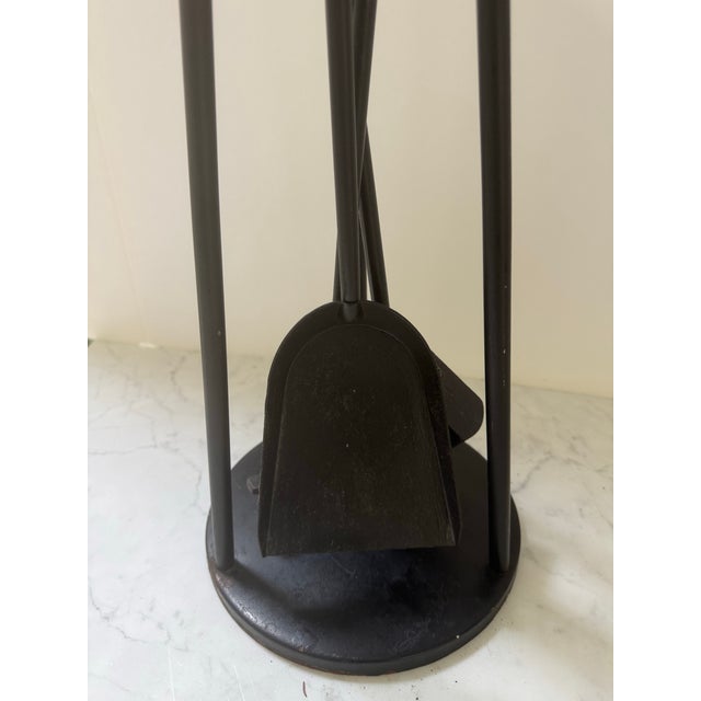 A vintage set of fireplace tools made of wrought iron with brass handles. The set has clean lines and consists of a...