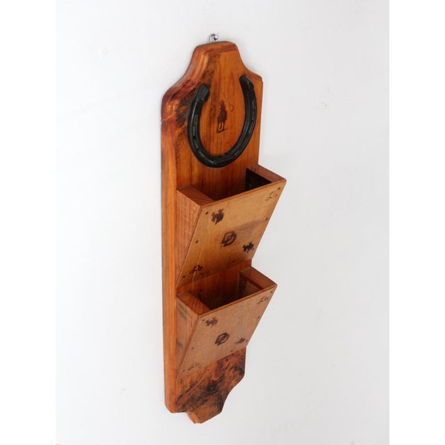 A vintage Western wall organizer handcrafted from wood and accented with an iron horseshoe. Hand-burned designs of...