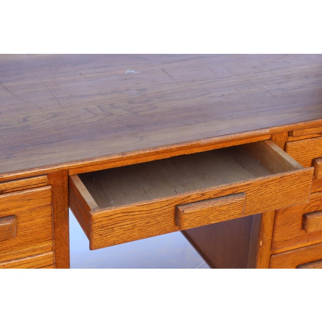 A handsome solid oak pedestal desk from the 1940s, with the unmistakable proportions and craftsmanship of mid-century...