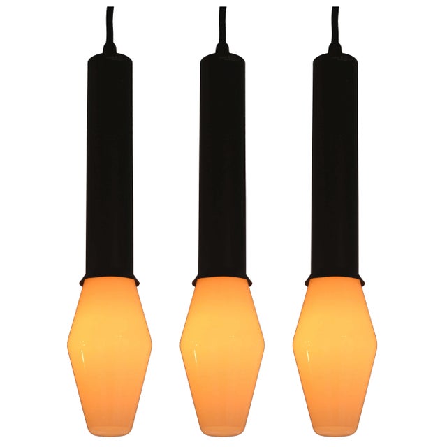 1960s Tapio Wirkkala Pendants for Idman, Executed in black painted metal and rare blown-glass architectural bulbs. Retains...