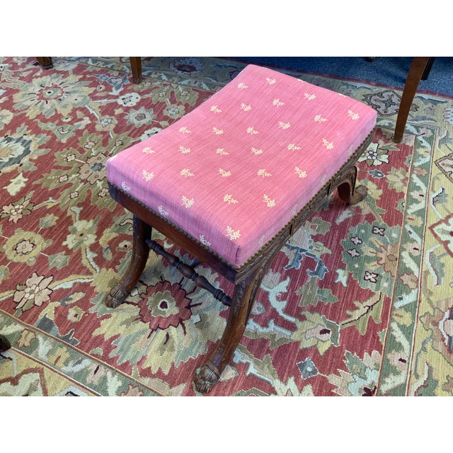 20th century Neoclassical footstool. Wood base upholstered top. Cerule style base with paw foor carved detail.