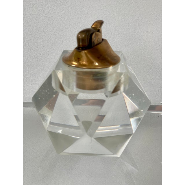 A faceted, lucite "ice cube" table lighter from the 1970s. The lighter part is made of brass and it can be removed from...