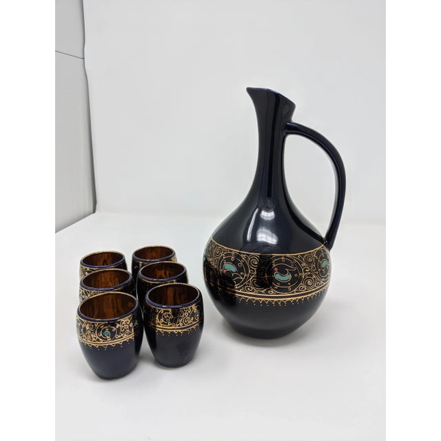 This ornate navy blue and gold leaf carafe and shot glass set includes one (1) carafe and six (6) small glasses. This set...