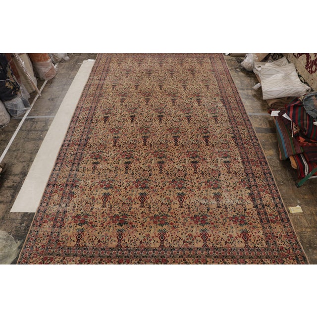 Hand-knotted in wool circa 1910-1920, this 9x17 antique Persian rug is a rare signature piece of Kerman Lavar...