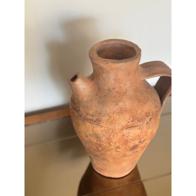 Rustic vintage clay vessel with a charming primitive design, crafted from terracotta with a natural earthy finish. Perfect...