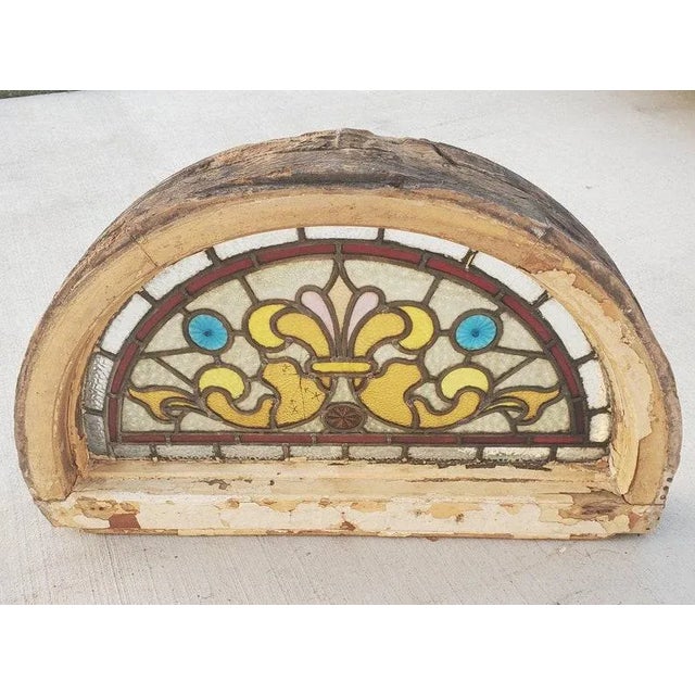 A most charming original antique French Victorian framed stained glass overdoor fanlight window, with a combination of...