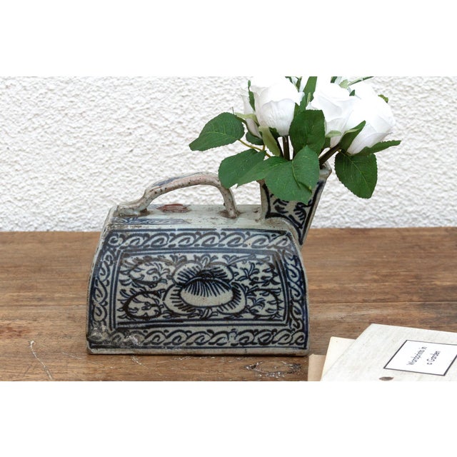 This captivating porcelain vessel, adorned with a tapestry of blue and white floral motifs and geometric patterns, speaks...