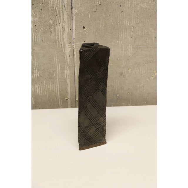 Black studio pottery leaning vase in a triangle form. All sides feature etchings.